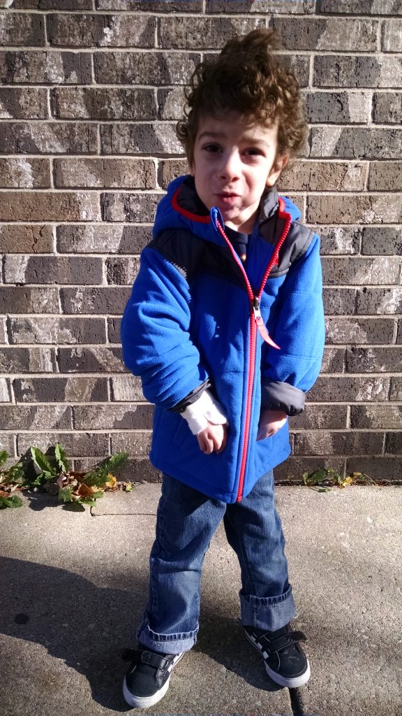 Aleck modeling his new coat outside of his preschool.